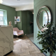 Office reception with green walls, pink armchair and white marble reception desk