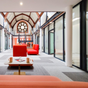 Office space in modernised church. Red seating and grey carpet with white architecture